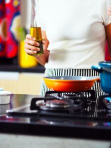 Someone who is about to cook, holding a bottle of sesame oil