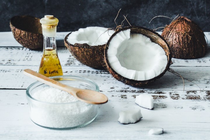 Raw coconuts, coconut flakes and coconut oil in a bottle.