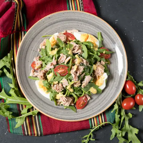 Chicken salad in a plate with cherry tomatoes on the side