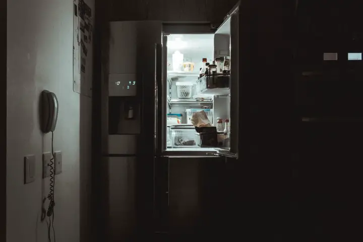 Fridge with an open door in the dark