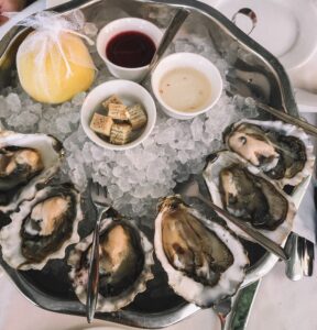 Oysters placed on ice with lemon and other toppings besides them