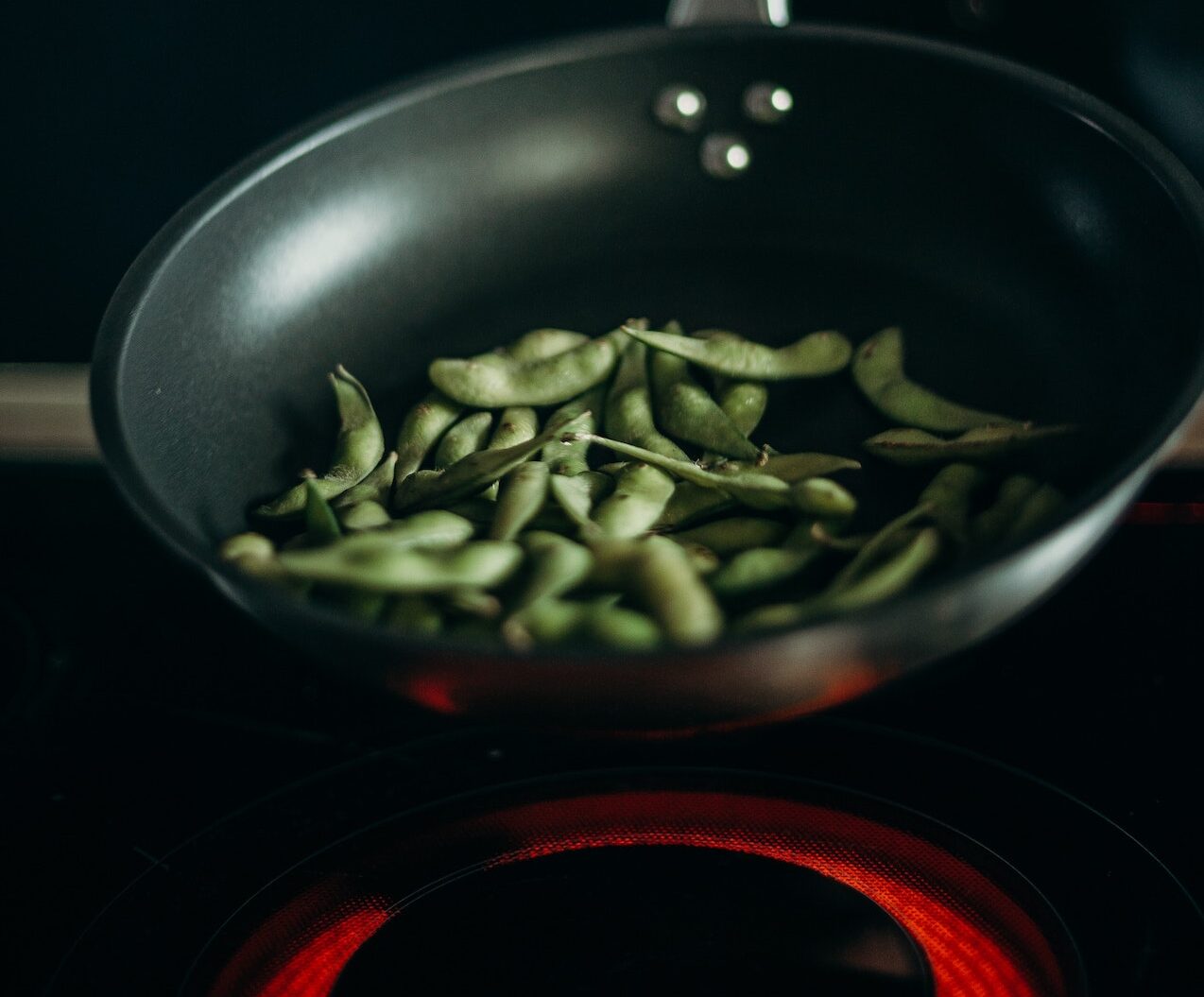 Edamame being cooking in a pan